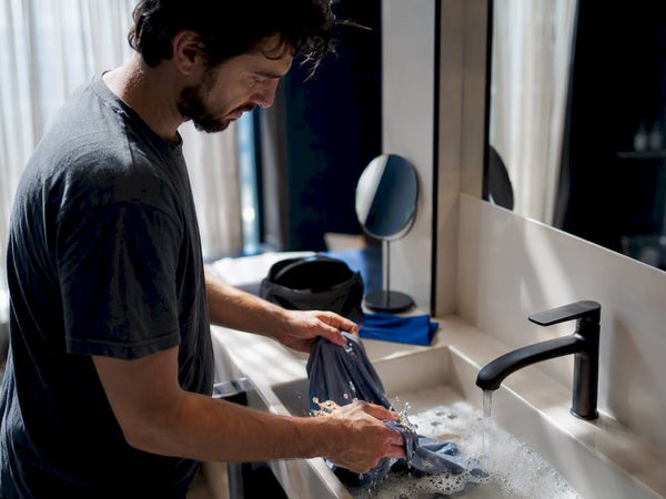 Hands washing shirt in hotel sink