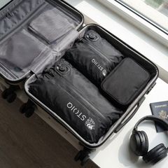 Stoiq Cable Organizer packed in a carry-on with two Stoiq compression bags